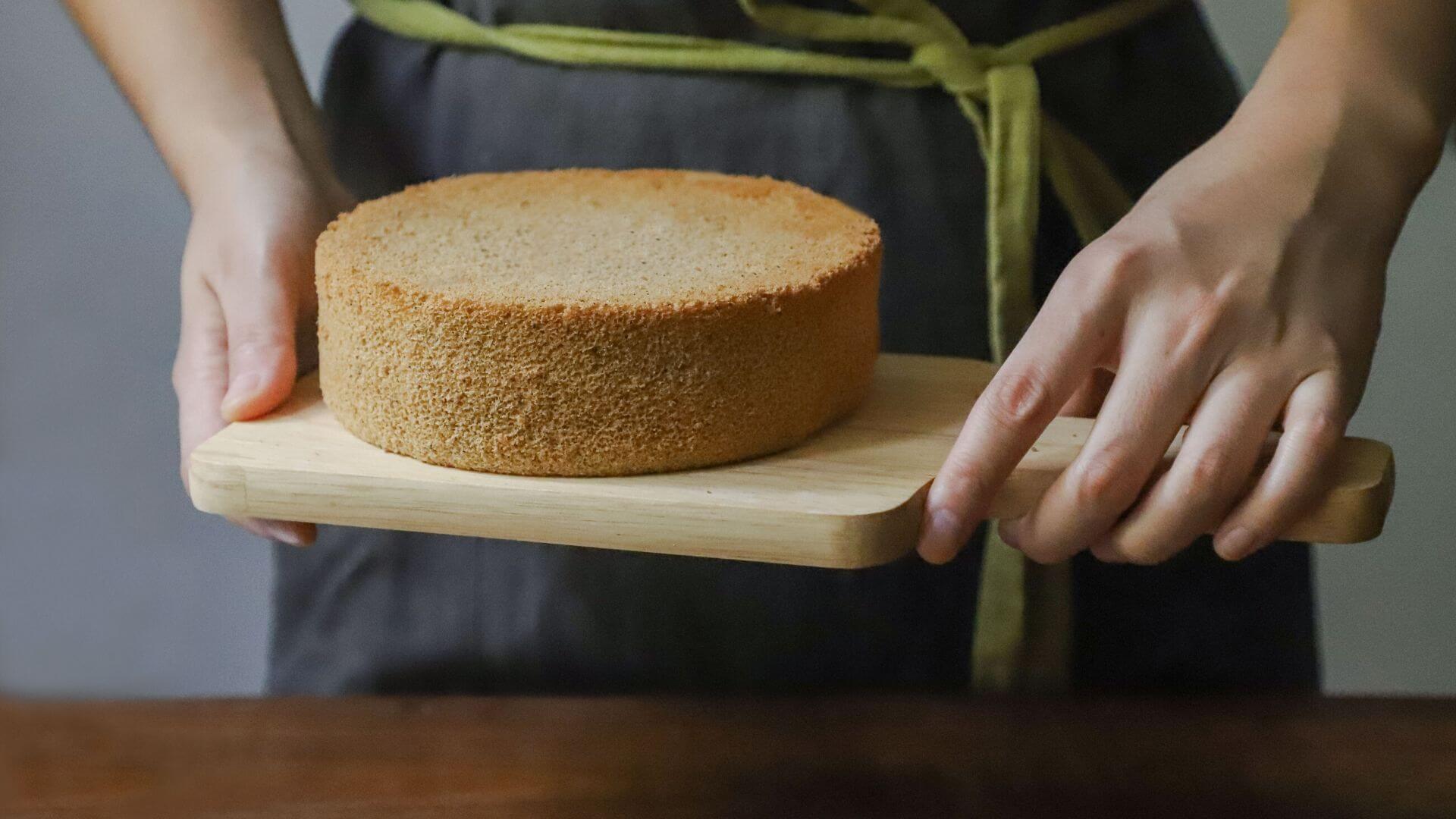 Woman Holding a wooden board with cake on it