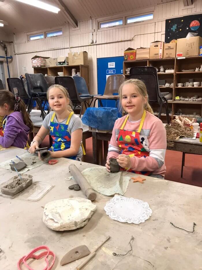 Two girls making pottery