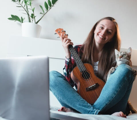 image of person holding ukulele and a cat